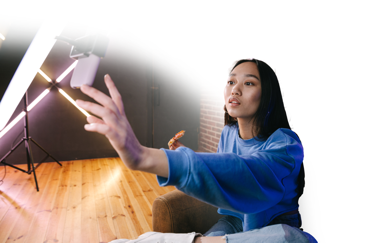 Woman filming a TikTok in front of a ring light and iPhone.